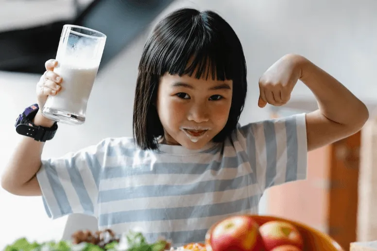 Anak perempuan sedang minum susu