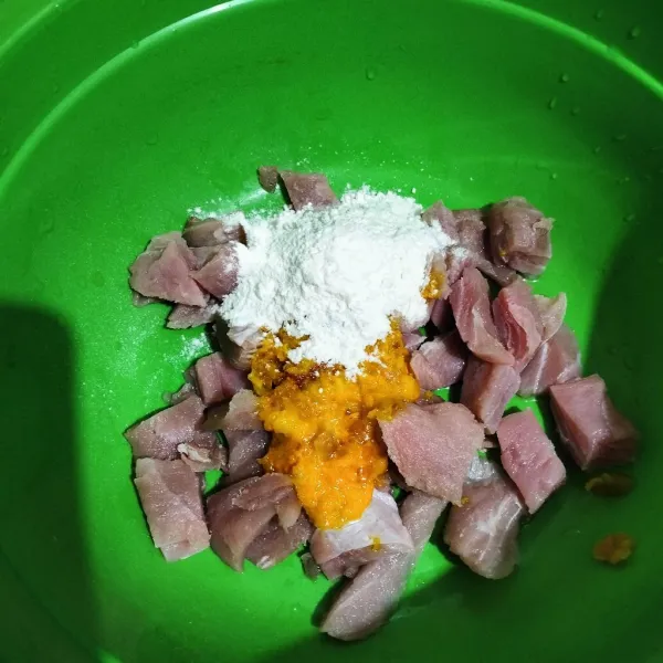 Masukan bumbu ulek, terigu dan susu ke dalam wadah ikan.