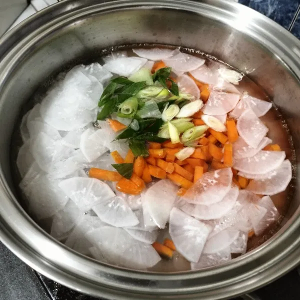 Dalam panci, didihkan air. Lalu masukkan wortel, lobak dan bawang prei. Rebus sampai empuk.