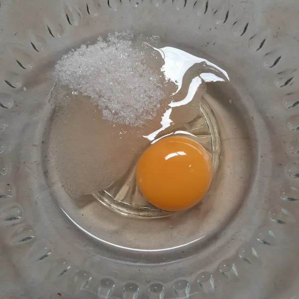 Masukkan telur dan gula pasir ke dalam wadah, lalu kocok lepas