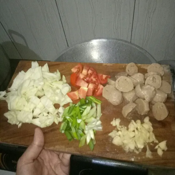 Cuci bersih dan iris kubis, bakso, tomat, daun bawang dan bawang putih.