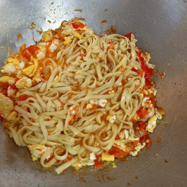 Masukkan mie gepeng, tumis dengan bumbu.
