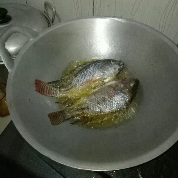 Siapkan pan dan panaskan minyak. Goreng ikan nila sampai setengah matang. Angkat, lalu tiriskan
