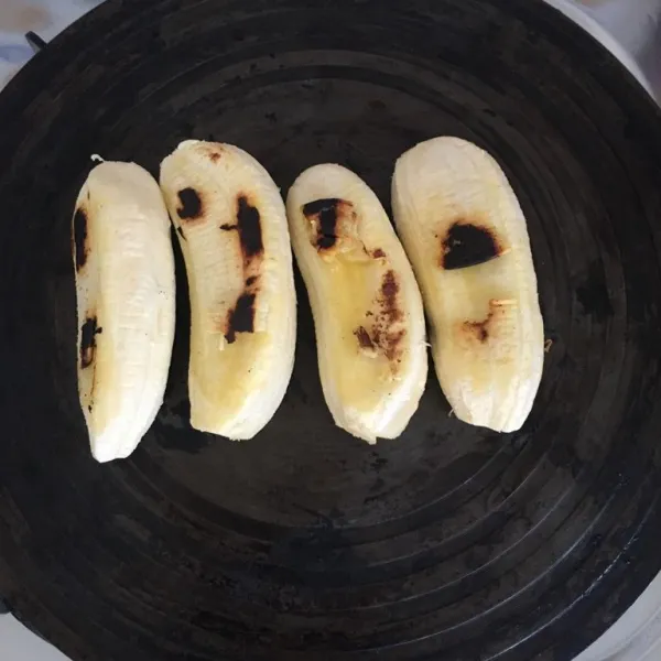 Kupas pisang, tata di dalam wajan anti lengket yang sudah dipanaskan. Panggang pada kedua sisi hingga matang, kurang lebih selama 5 menit pada masing-masing sisi pisang.
