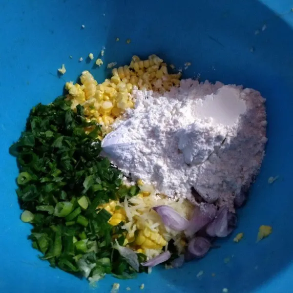 Masukkan irisan halus daun seledri dan daun bawang, serta masukkan bawang putih, bawang merah, tepung terigu, dan tepung beras, aduk rata.