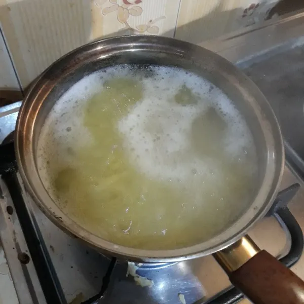 Rebus kentang yang sudah diparut ke dalam air mendidih selama 7 menit. Angkat dan tiriskan. Setelah dingin, peras kentang dengan kain bersih