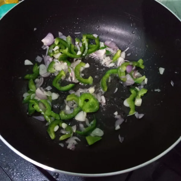 Panaskan minyak dalam wajan. Tumis bawang merah, bawang putih, dan paprika hijau hingga harum
