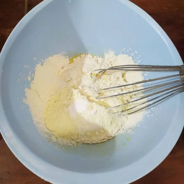 Masukkan tepung terigu, susu bubuk, soda kue, dan baking powder dengan cara diayak