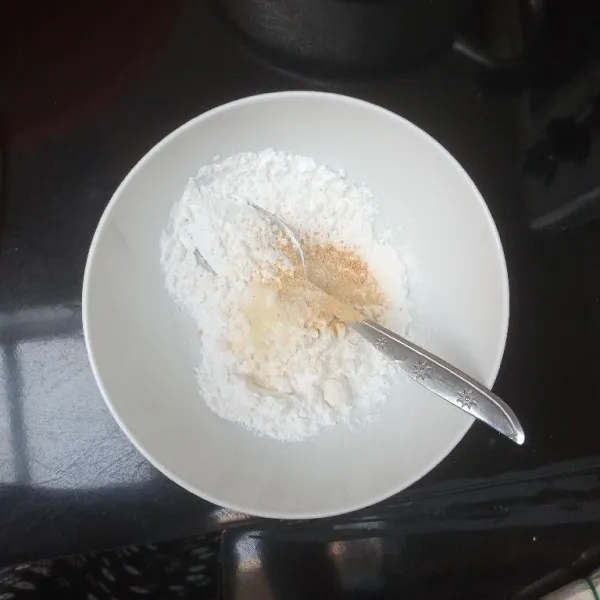 Masukkan tepung tapioka, tepung terigu, garam, gula, merica, dan bawang putih bubuk ke dalam mangkuk, lalu aduk rata