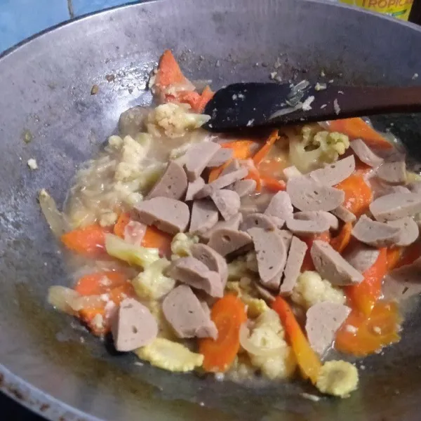 Masukkan irisan bakso, aduk rata. Masukkan juga, saus tiram, garam, kaldu bubuk, minyak wijen. Masak rata.
