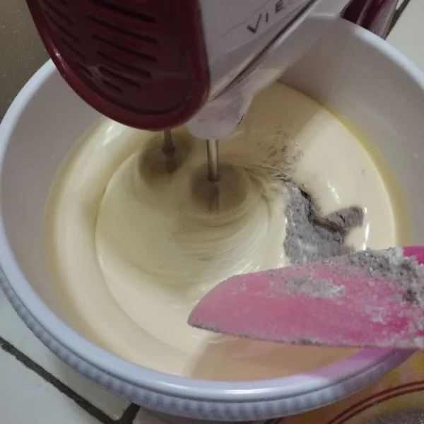 Turunkan kecepatan mixer ke yang paling rendah. Masukkan campuran tepung ketan, tepung terigu, dan vanili yang sebelumnya sudah diayak dulu. Masukan tepung secara bertahap dan bergantian dengan santan instan. Lakukan sampai habis dan matikan mixer