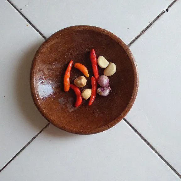 Haluskan cabai rawit, bawang merah, bawang putih, dan kemiri.