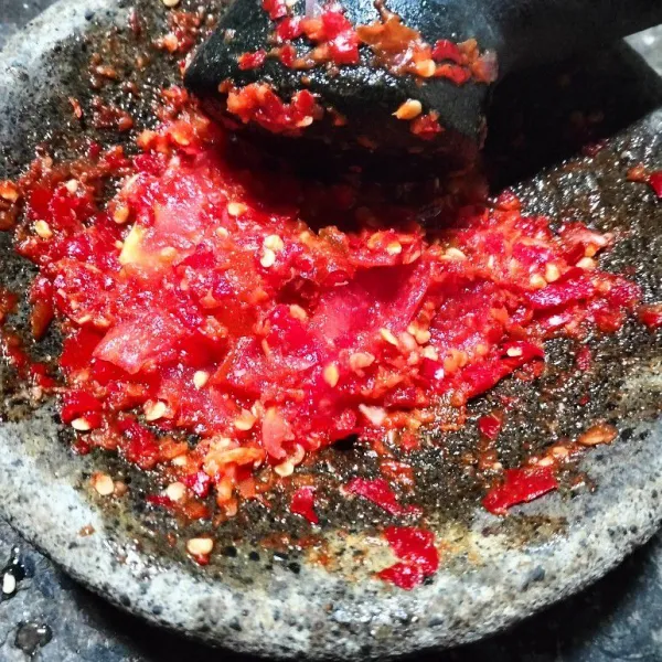 Haluskan bawang merah, bawang putih, cabai, dan tomat.