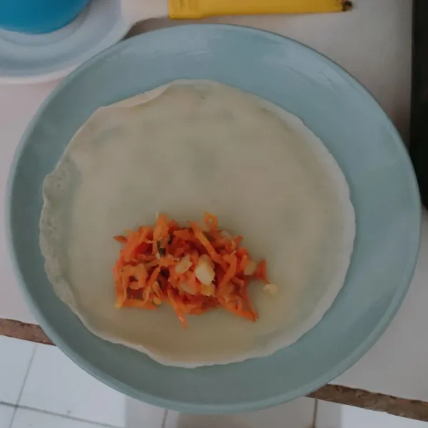 Beri isian kulit risol dengan satu sdm tumisan kentang wortel, lipat lalu gulung.