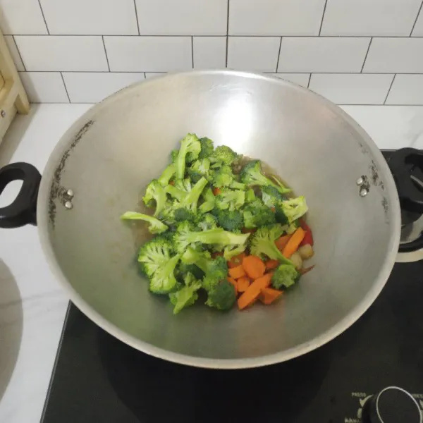 Masukkan irisan wortel dan brokoli.