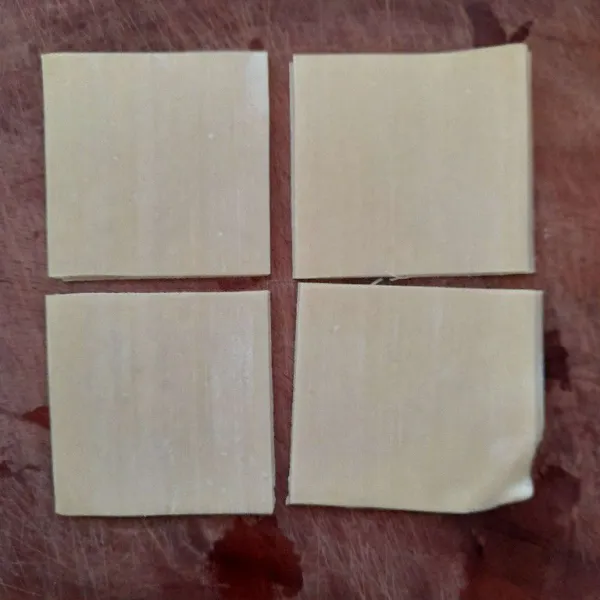 Potong kulit pangsit menjadi 4 bagian.