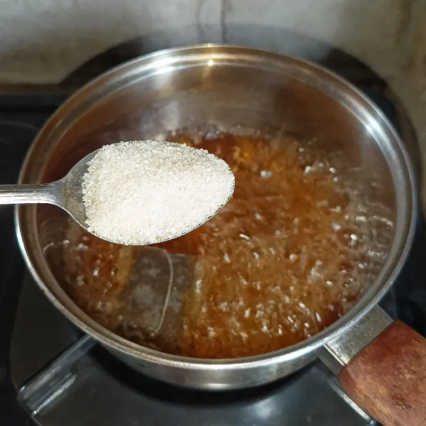 Setelah mendidih masukkan gula pasir dan aduk-aduk sampai gula larut, matikan kompor dan biarkan sampai hangat.