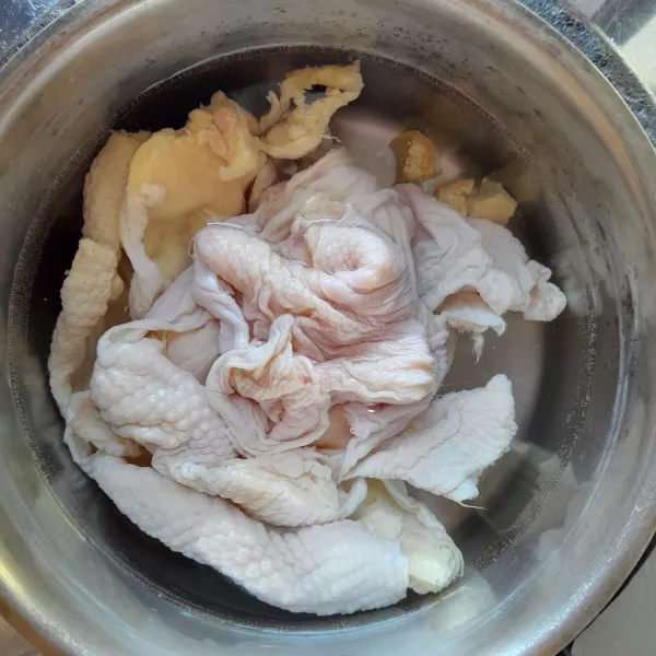 Siapkan panci,masukkan 500 ml air,irisan jahe dan kulit ayam. Rebus kulit ayam hingga cukup empuk,kurang lebih 15 menit. Angkat.