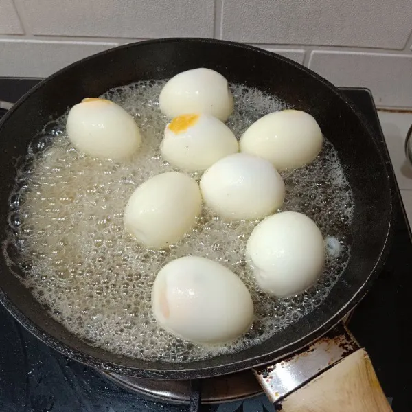 Biarkan minyak sisa goreng tempe lalu matikan kompor dan masukkan telur rebus yang telah dikupas. Fungsinya agar kulit telur cantik merata (prosesnya saat kompor mati ya). Angkat dan sisihkan.