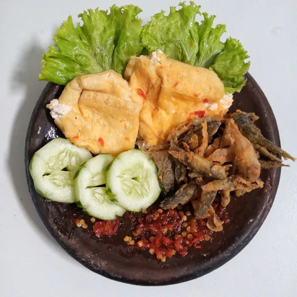 Tambahakan ikan, tahu dan timun di atas sambal. Sajikan.