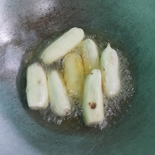 Panaskan minyak goreng, masukkan pisang masak sampai setengah matang.