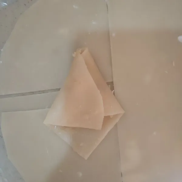 Letakkan isian di kulit lumpia, kemudian lipat menjadi segitiga
