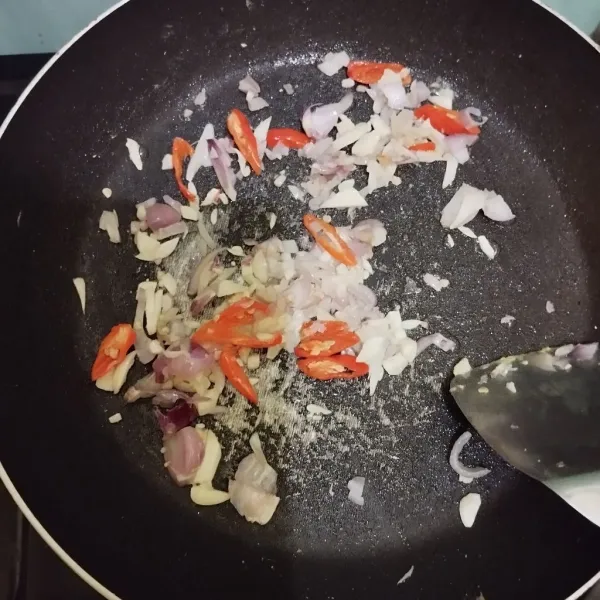 Tumis irisan bawang merah, bawang putih, dan cabai hingga layu