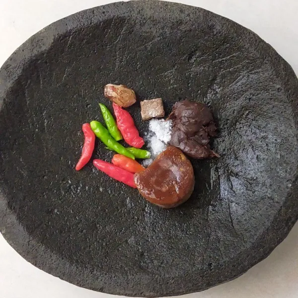Siapkan cobek, lalu masukkan cabai rawit merah, cabai rawit hijau, kencur, terasi udang bakar, asam jawa, gula merah dan garam.
