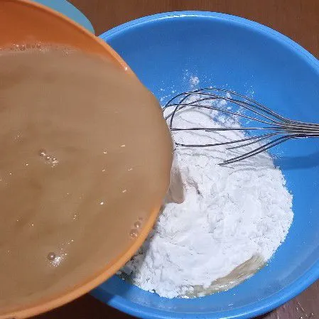 Di wadah lain campur tepung beras dan tapioka tuang air gula yang sudah hangat aduk rata lalu saring.