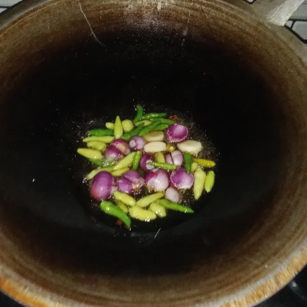 Selanjutnya, goreng cabai rawit, bawang merah, dan bawang putih hingga matang dan layu.