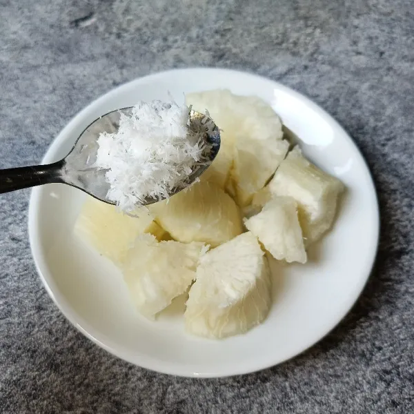 Tata singkong dipiring dan taburi dengan kelapa parut yang sudah dicampur dengan sejumput garam.