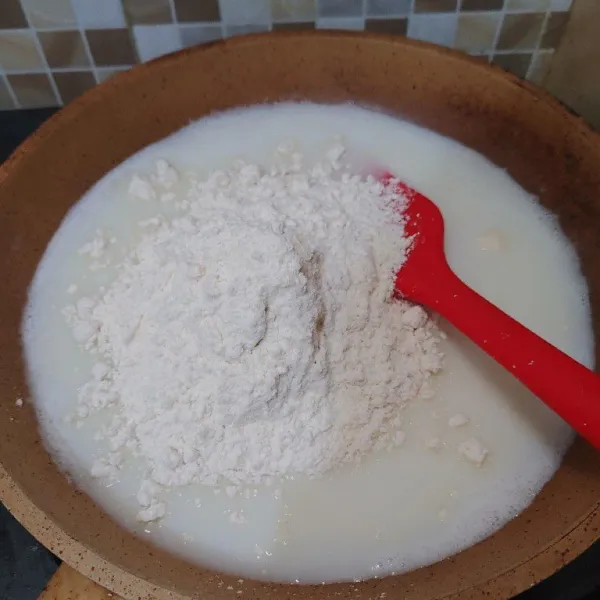 Nyalakan api, tunggu susu sampai pinggirannya berbuih. Lalu masukkan tepung terigu, kecilkan api.