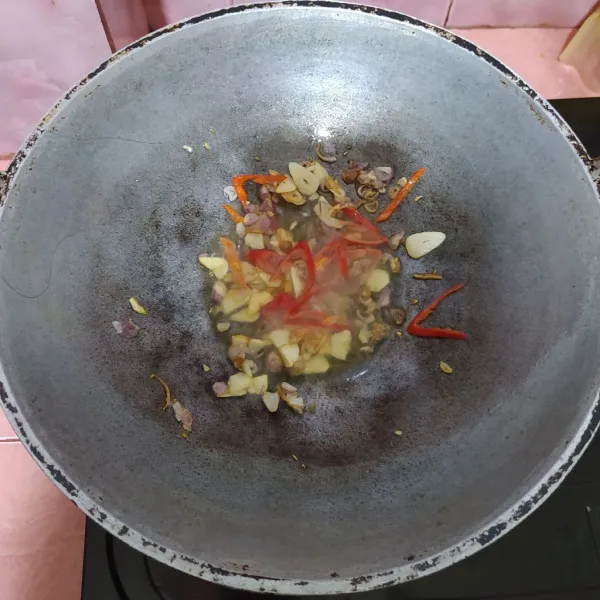 Tumis bawang merah dan bawang putih sampai wangi. Masukkan cabe merah.