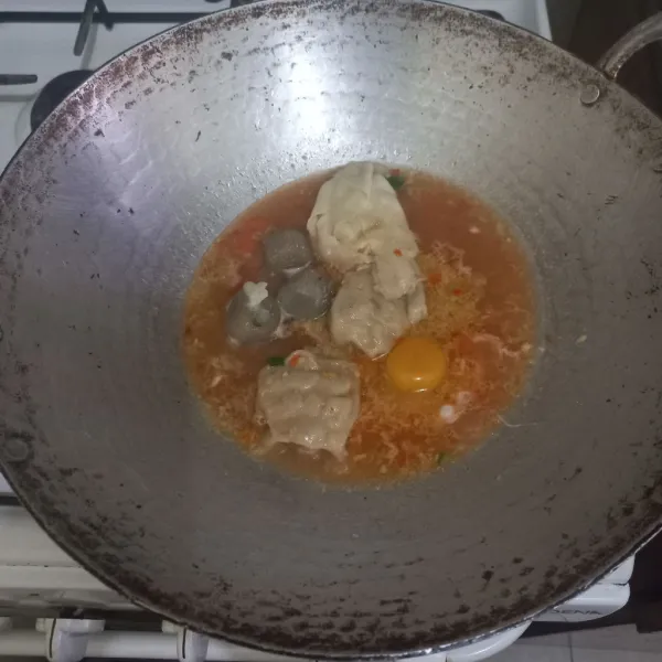 Pecahkan telur ayam kampung dalam wajan.