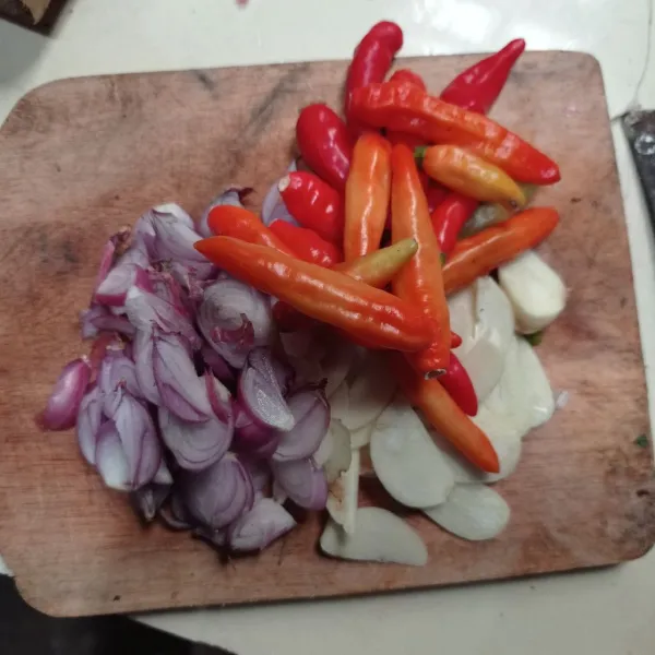 Iris bawang merah, bawang putih, siapkan cabe utuh juga.
