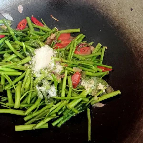 Masukkan batang kangkung, garam, kaldu bubuk, gula. Masak hingga agak layu sekitar 3 menit.