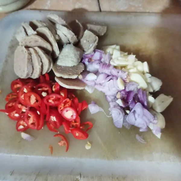 Iris tipis dan cincang bawang putih dan bawang merah. Iris tipis bulat bakso dan iris halus cabai.