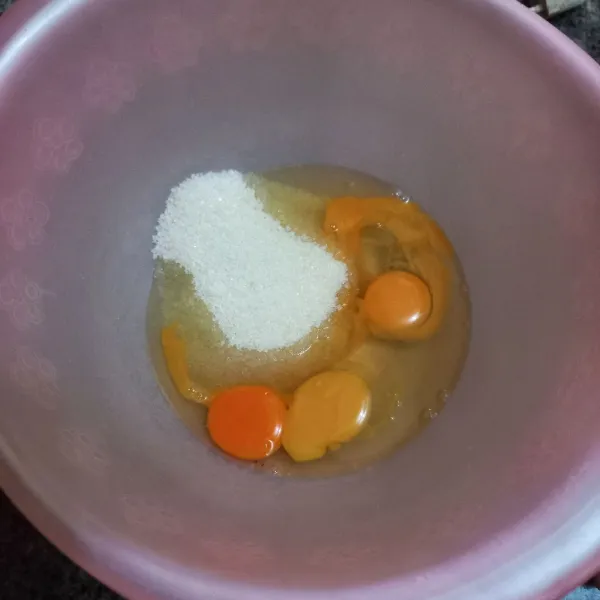 Dalam wadah, kocok telur ayam dan gula pasir hingga menjadi adonan putih berjejak