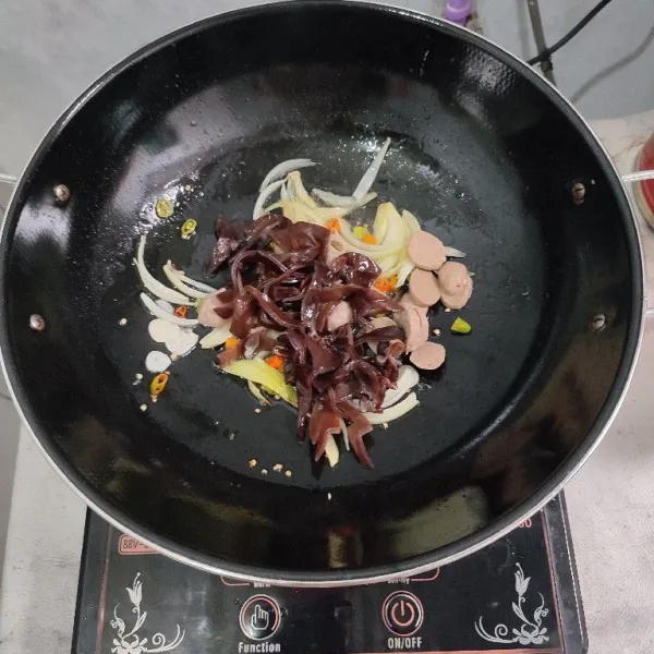 Masukkan jamur kuping dan bakso tumis sebentar.