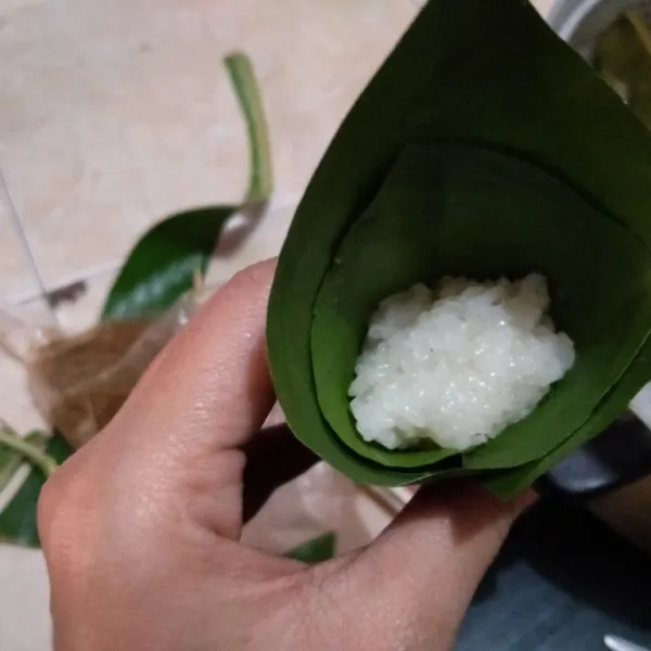 Masukkan 1 sdm ketan, kemudian 1 sdt abon, tutup dengan 1 sdm ketan lagi, tekan padatkan secara perlahan.