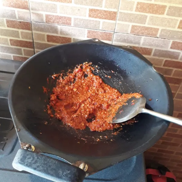 Masukkan sambal dalam wajan. Tambahkan tiga sendok makan minyak. Bumbui dengan garam, vetsin, terasi, dan gula. Masak hingga matang dan gula larut