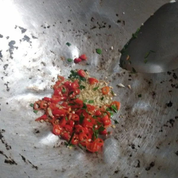 Masukkan cabai dan daun jeruk. Aduk-aduk hingga cabai dan daun jeruk kering.