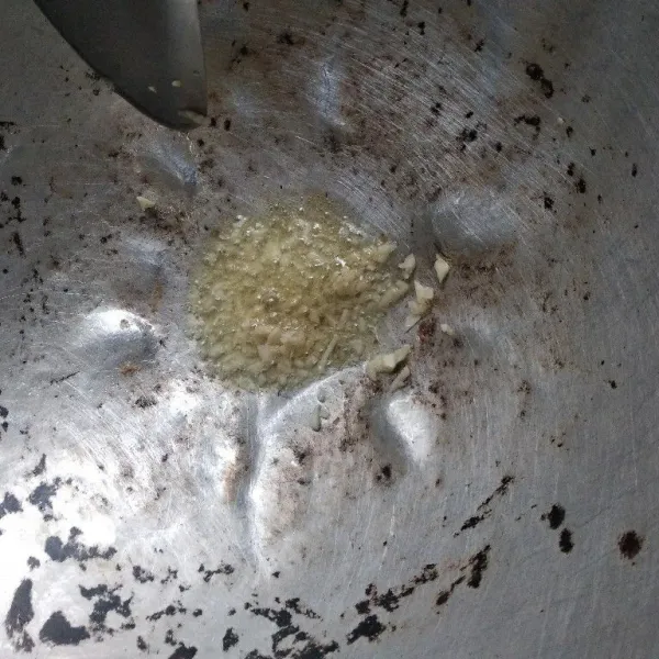 Ambil satu sendok makan minyak sisa menggoreng tempe. Tumis bawang putih sampai kering.