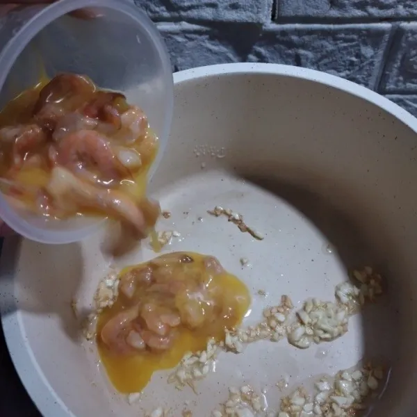 Campur udang dengan telur yang telah dikocok, lalu tuang ke dalam tumisan bawang putih