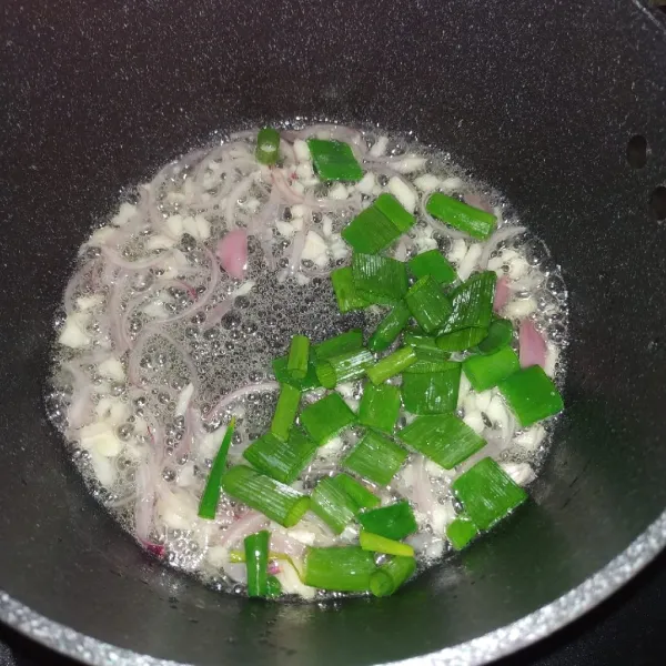 Tambahkan daun bawang, masak hingga layu.