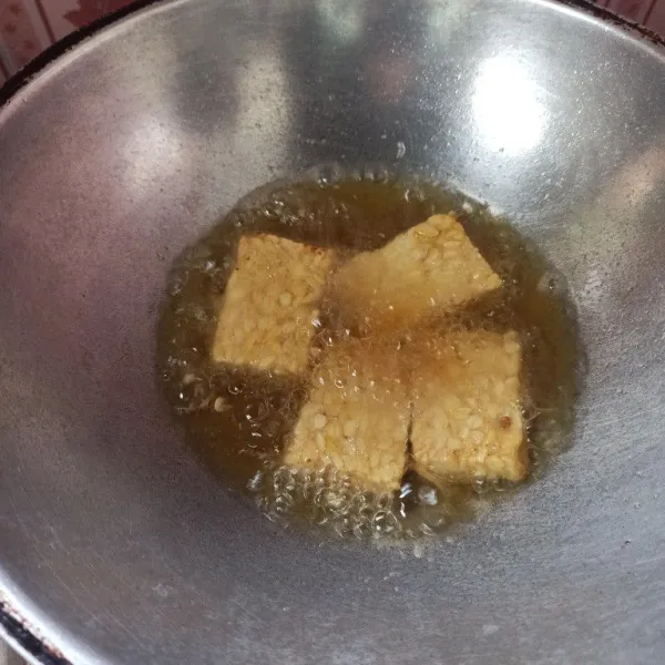 Rendam tempe dengan air garam kemudian goreng hingga matang, setelah matang angkat dan tiriskan.
