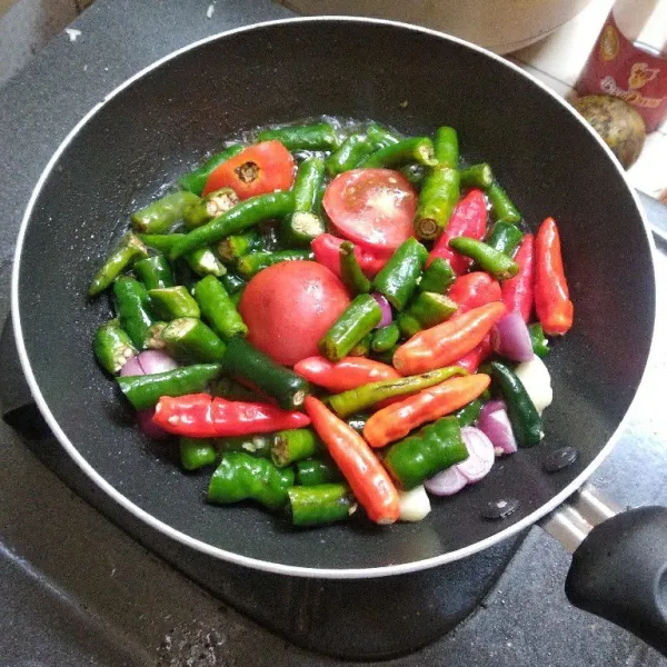 Goreng bawang merah, bawang putih, cabe dan tomat merah sampai matang.