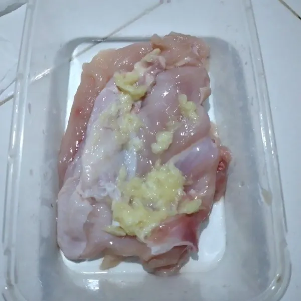 Marinasi ayam dengan bawang putih dan garam sambil diremas remas.