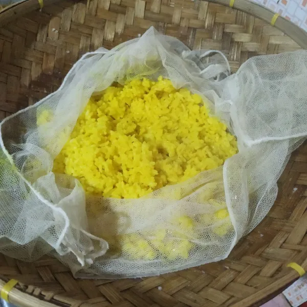Setelah matang, angkat. Kipas-kipas sambil diaduk agar uap panasnya hilang, lalu sajikan nasi kuning dengan pelengkap lainnya