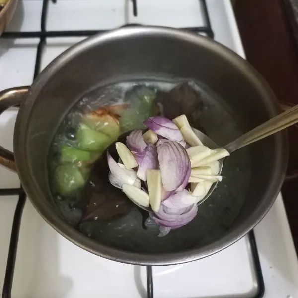 Tambahkan irisan bawang merah dan bawang putih.